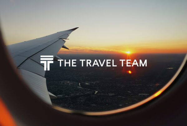The Travel Team logo against a photo taken from a plane window