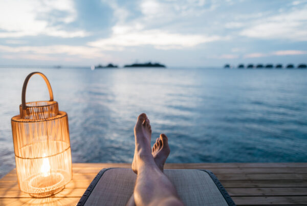 Person sitting on a dock with a lantern