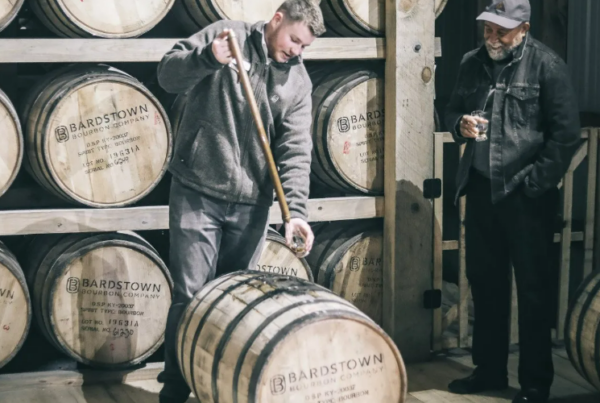 employee pulls bourbon from a barrel