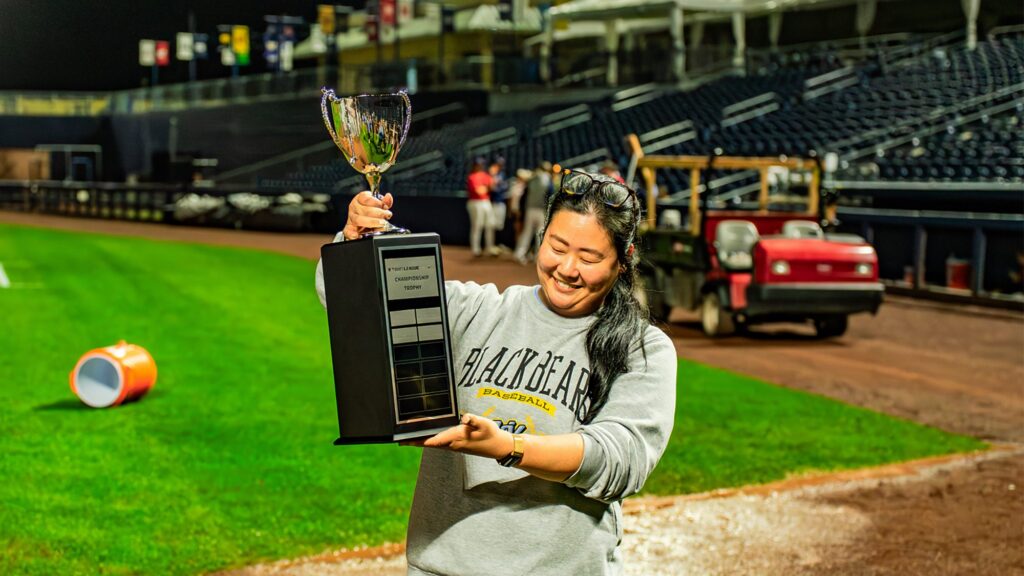 Leighann Sainato holds trophy on the field