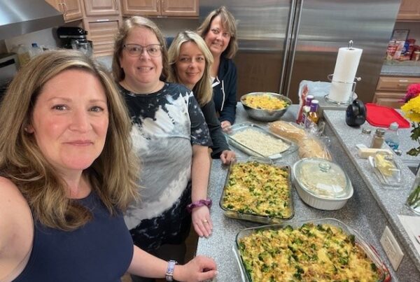 The Travel Team associates smile while preparing dinner